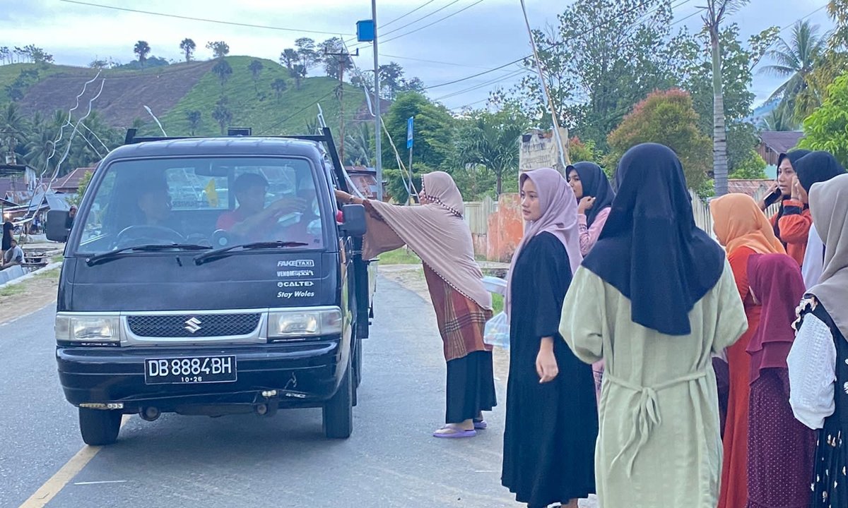 Para siswa dan guru di SMP Negeri 4 Monano, Kabupaten Gorontalo Utara, saat membagikan takzil ke penguna jalan. (Foto: Istimewa)